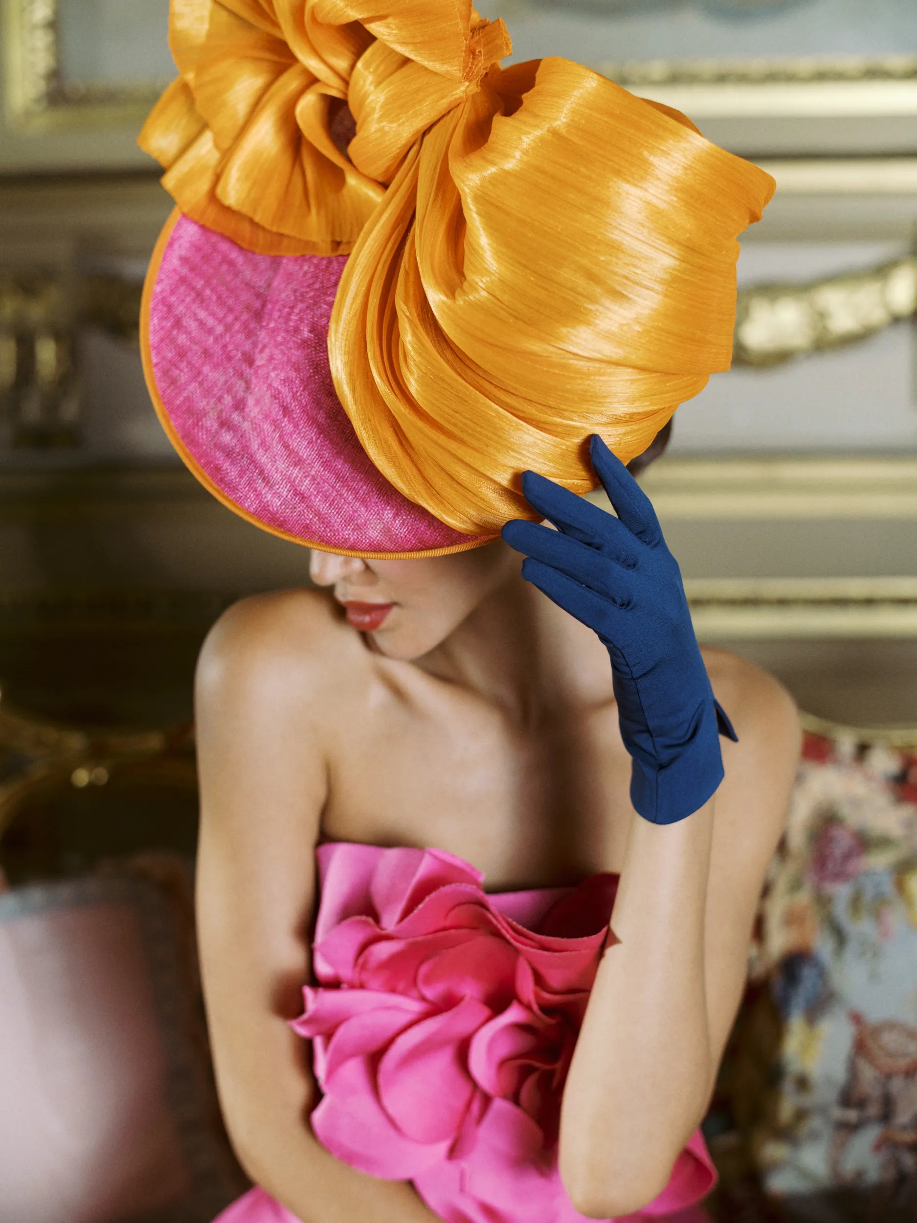 Woman touching her hat wearing blue wrist gloves.