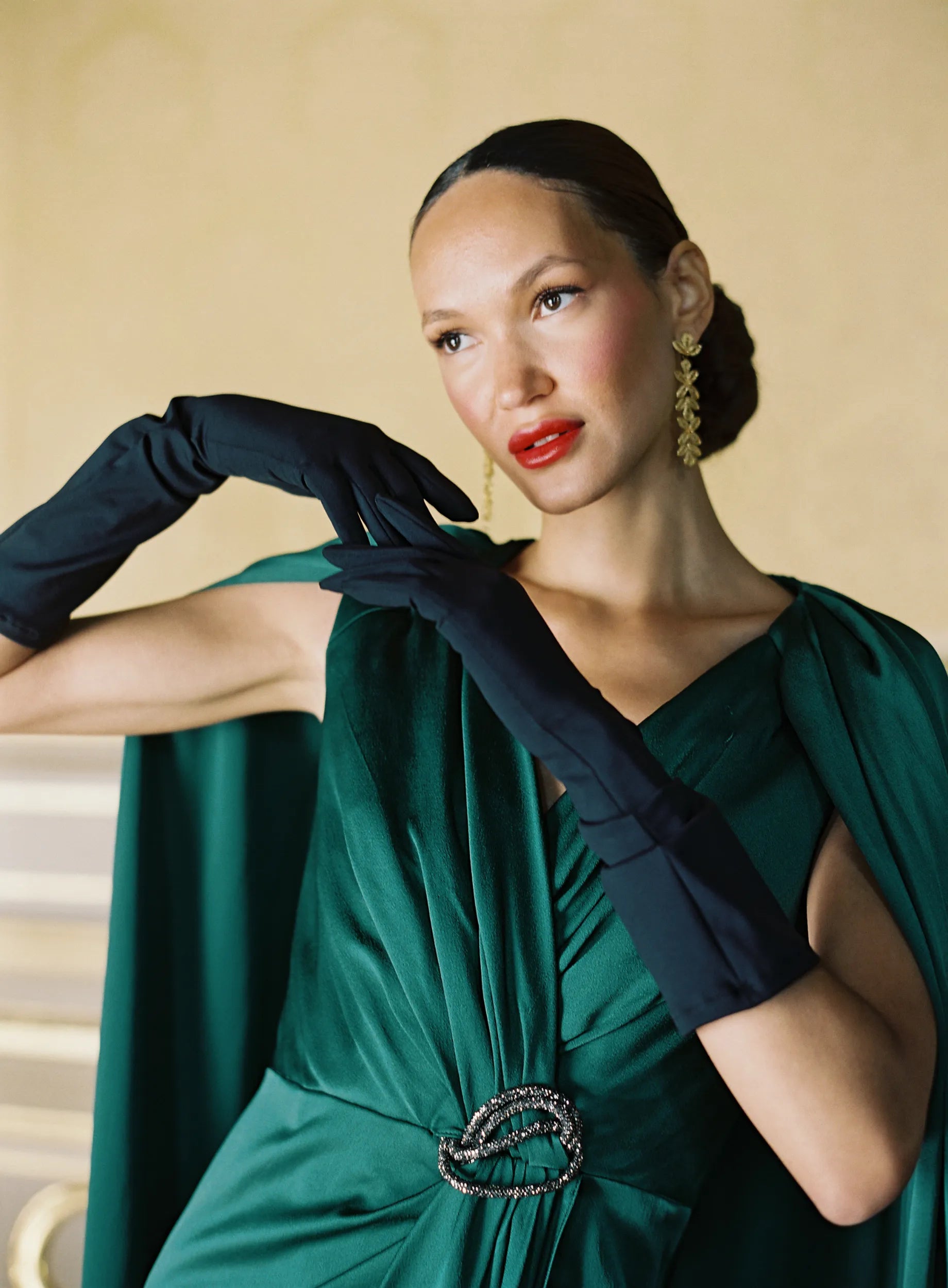 A women wearing black Jill gloves in green formal dress.