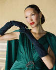 A women wearing black Jill gloves in green formal dress.