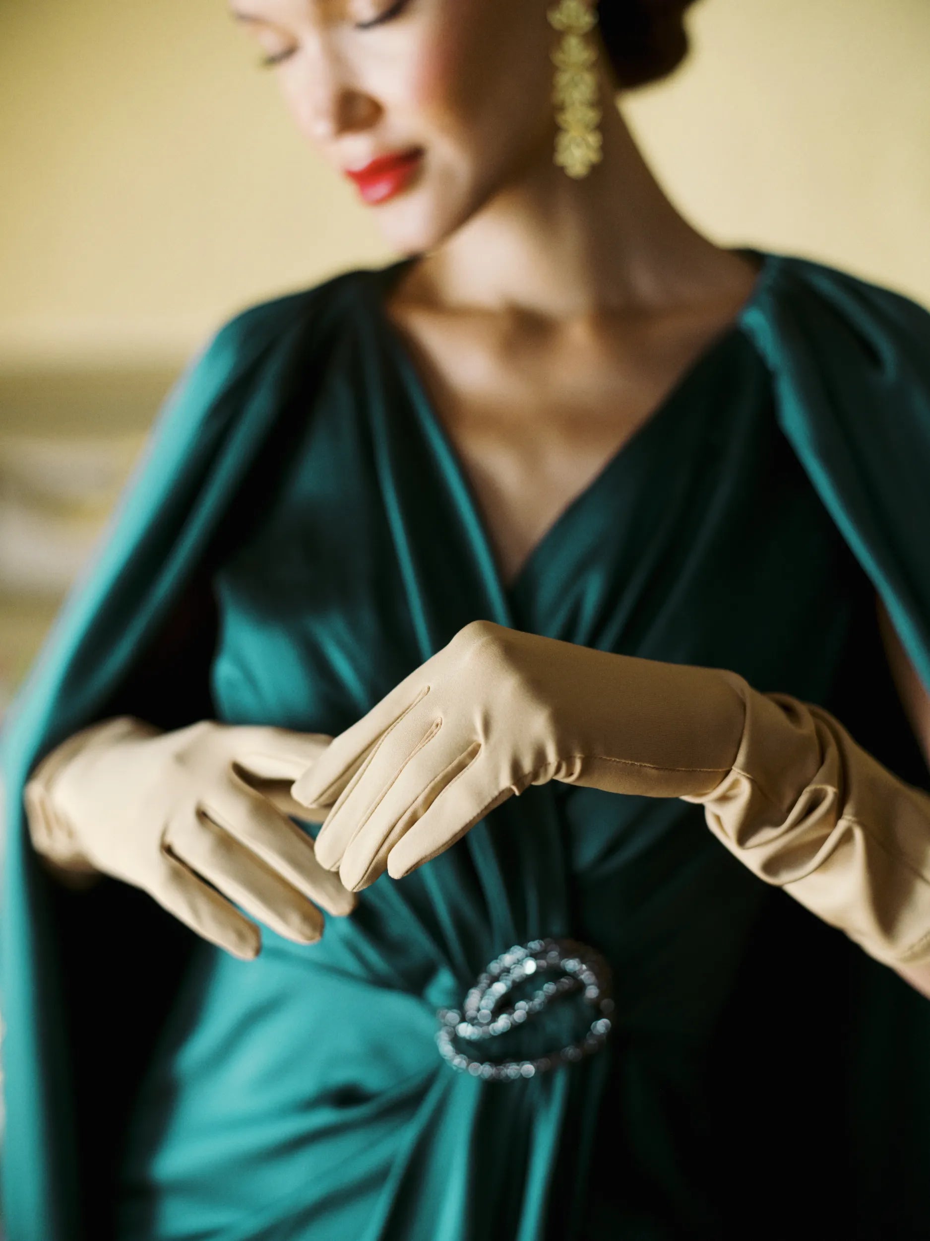 Women in elegant green dress with beige Ladyfinch gloves.