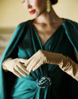 Women in elegant green dress with beige Ladyfinch gloves.