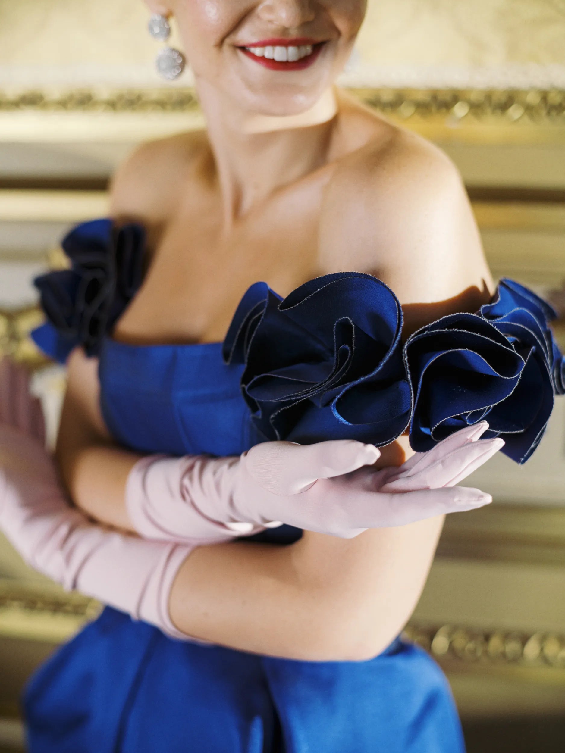 Woman smiling showing her pink formal gloves.