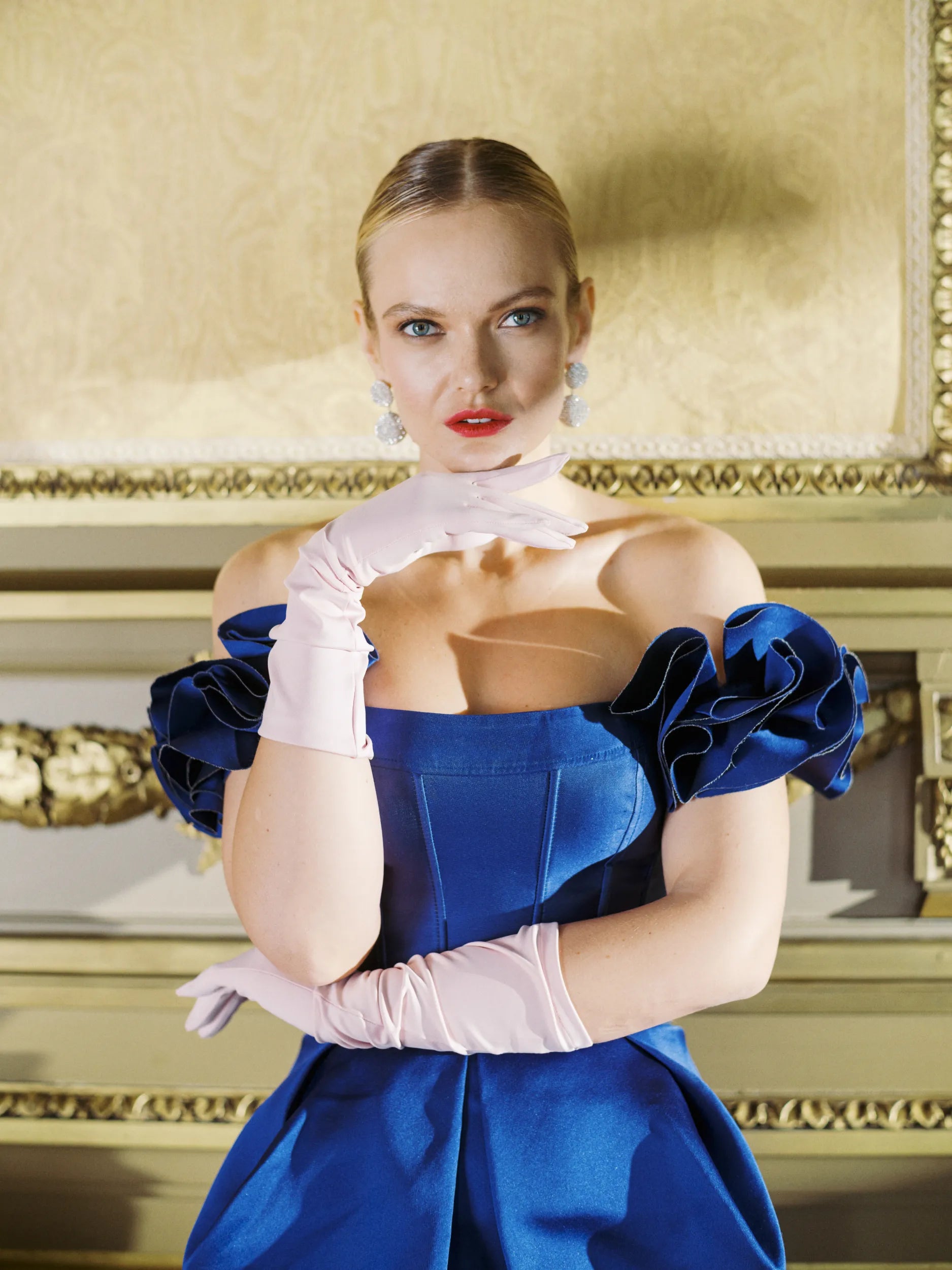 Elegant women wearing blue dress and formal pink gloves.