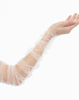 Close-up of a person's arm wearing THE KATHERINE - Opera Length Ruched White Tulle Gloves by LadyFinch, extending from the wrist to above the elbow.
