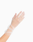 Womans hand wearing white tulle mid length ruched gloves.