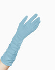 A woman wearing long elbow length, light blue gloves with an open palm.