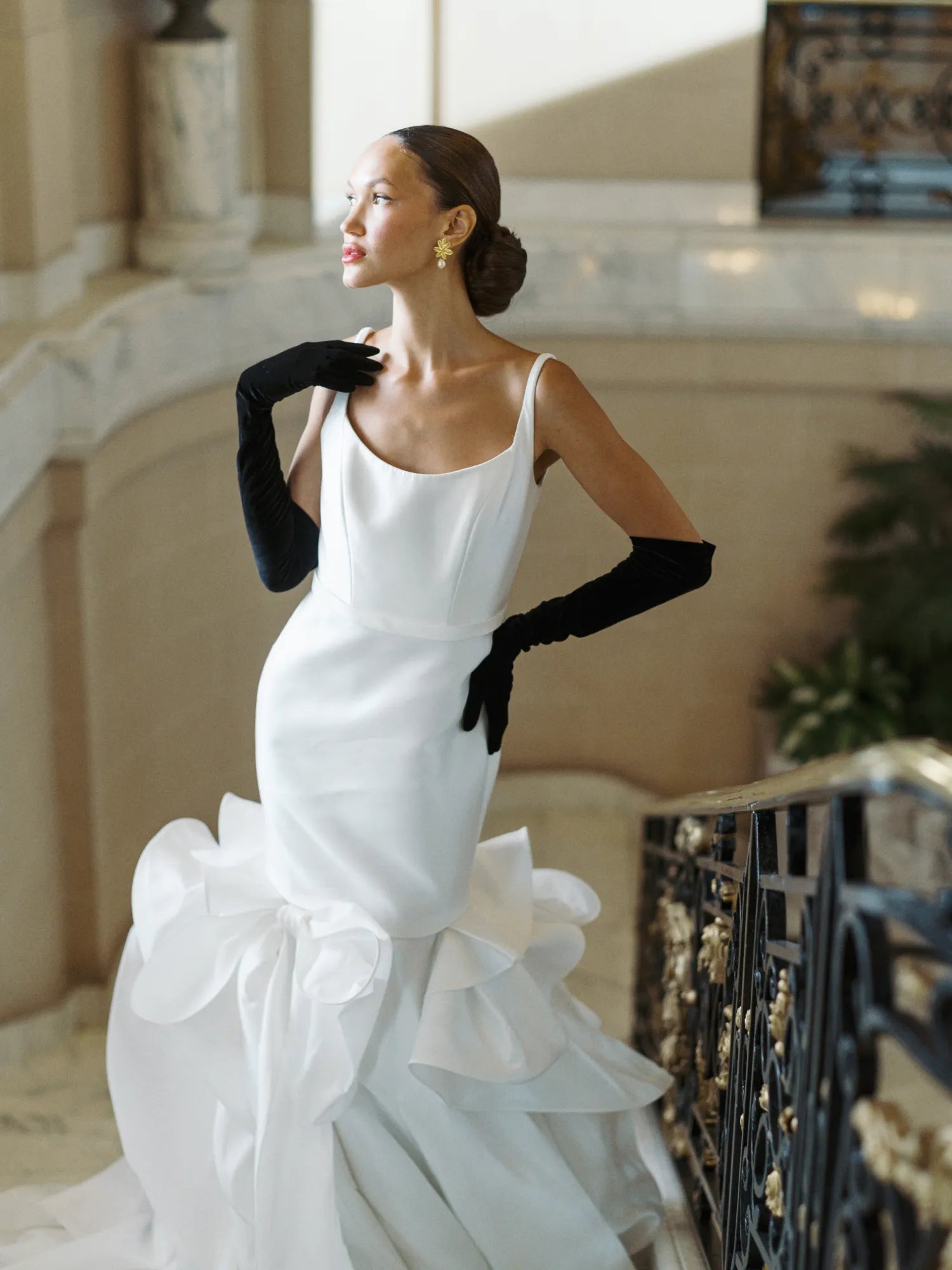 Bride posed with hand on hip, wearing opera long black velvet gloves.