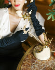 Woman wearing long black gloves holding vintage phone.