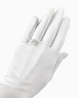 A hand wearing THE SUNNY - White Opera Gloves by LadyFinch and a diamond ring, displayed against a white background.