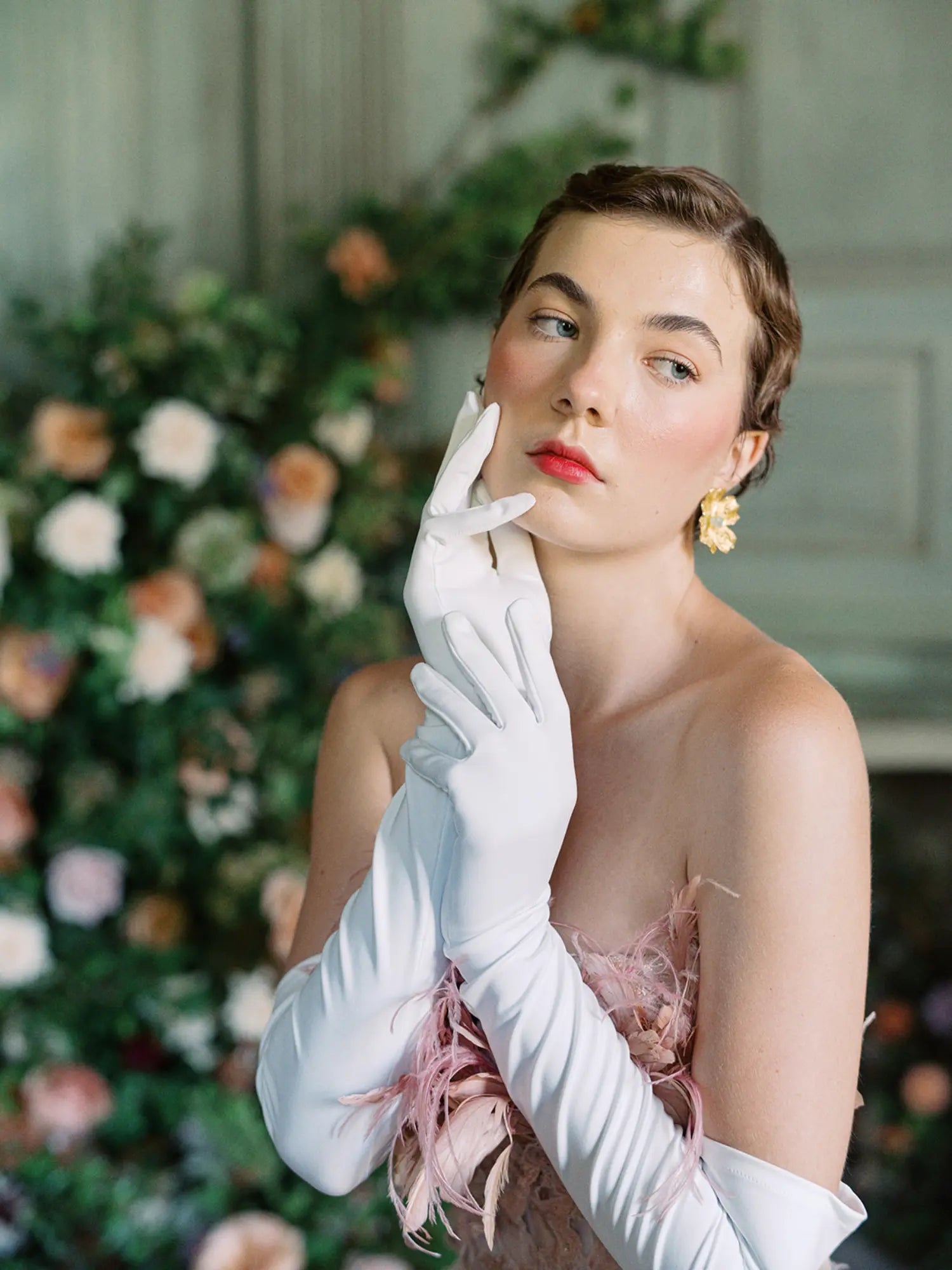 A woman in THE SUNNY - White Opera Gloves by LadyFinch exuding high-fashion elegance while posing for a photo at formal events.
