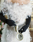 Woman wearing white feather dress wearing opera, long black gloves.