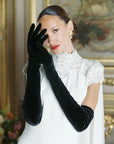 Bride wearing white dress and over the elbow long black gloves.