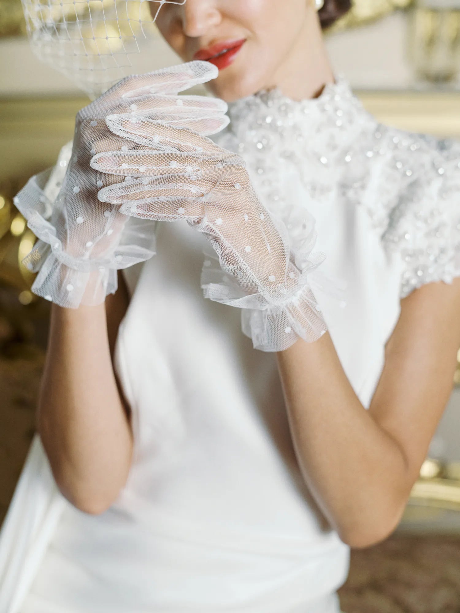 Women playing with hands wearing white tulle polka dot golves.