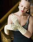 Poised woman wearing elbow length, long, elbow gloves.
