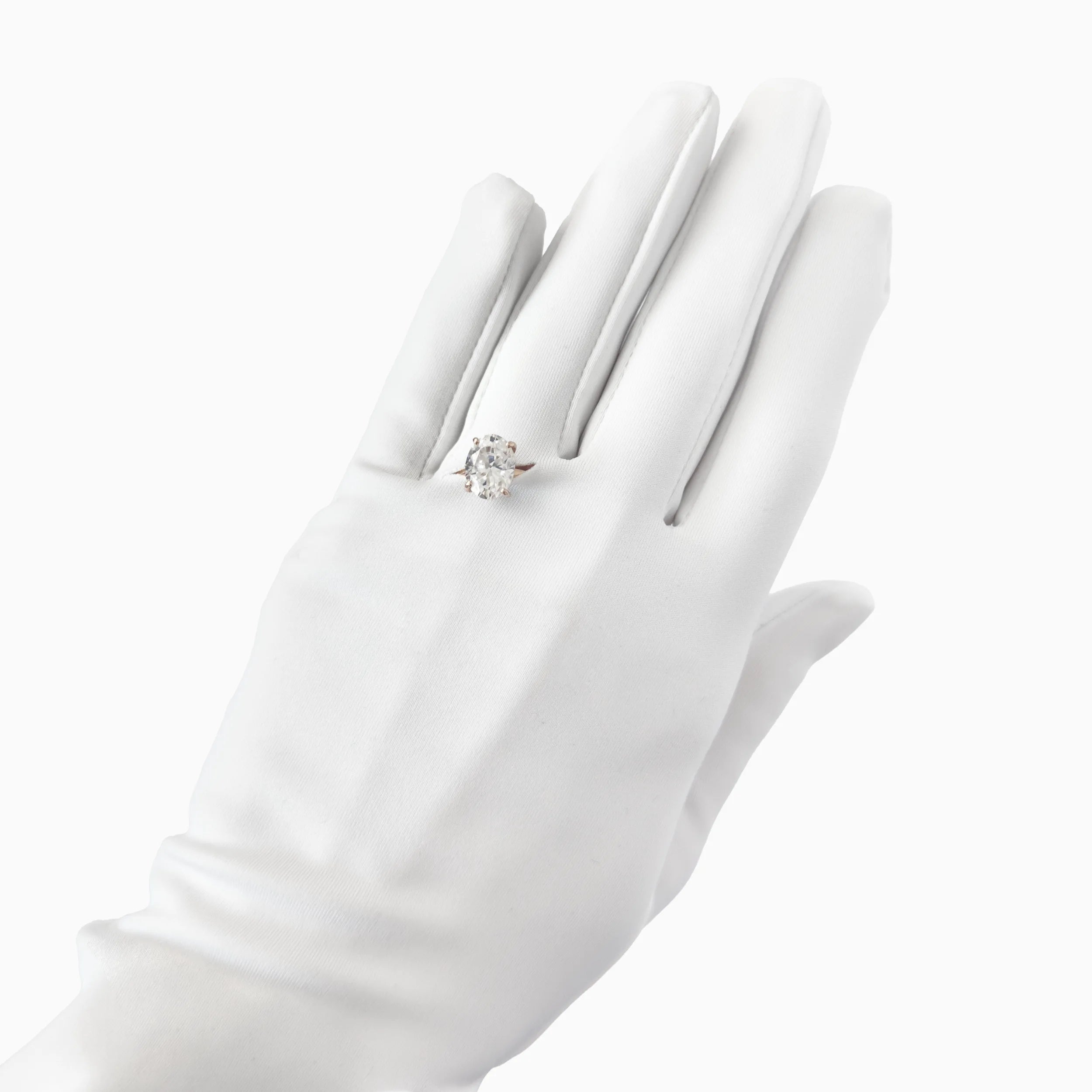 A hand wearing THE SUNNY - White Opera Gloves by LadyFinch and a diamond ring, displayed against a white background.